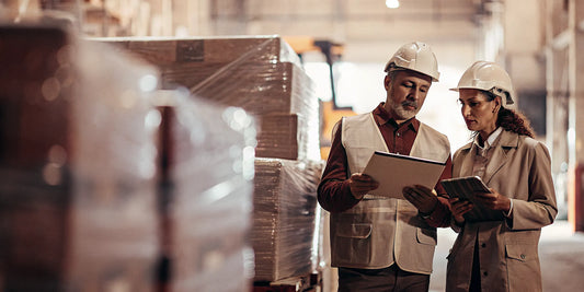 Logistics and procurement specialists reviewing a security seal order and volume pricing in a warehouse