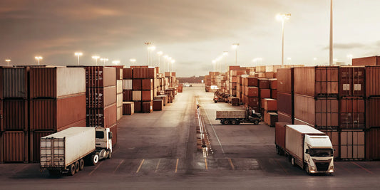 Aerial view of a cargo container yard with trucks and shipping containers at dusk