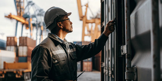 Logistics manager inspecting a cargo container with a high-security bolt seal at a shipping port